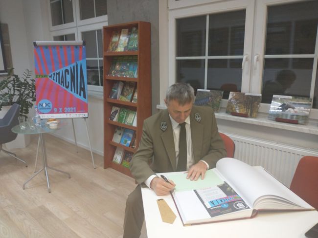Na zdjęciu pan Krzysztof Krupa wpisuję się do Kroniki Biblioteki