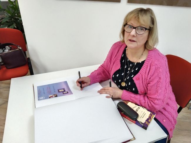Na zdjęciu autorka zostawia wpis w kronice