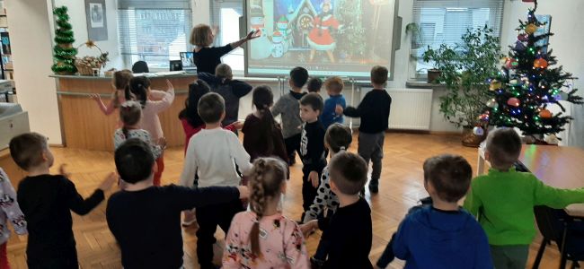 Zabawa taneczna. Dzieci tańczą do piosenki o zimie. Na tablicy interaktywnej wyświetlany jest teledysk.