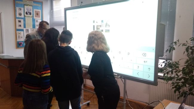 Uczniowie rozwiązują krzyżówkę na tablicy interaktywnej