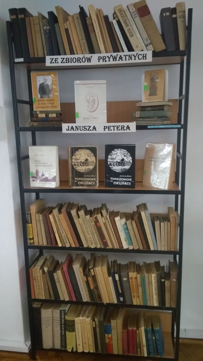 Na regale wystawa książek pochodzących ze zbiorów prywatnych Janusza Petera