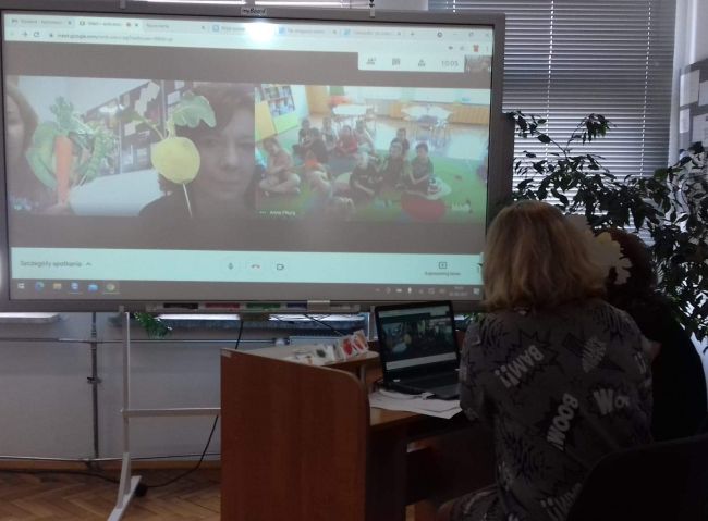 Nauczyciele bibliotekarze prowadzący zajęcia on-line oraz tablica interaktywna z grupą dzieci przedszkolnych