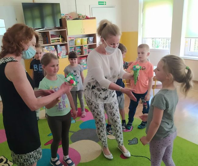 Przedszkolaki wręczają kwiaty nauczycielom bibliotekarzom za przeprowadzenie zajęć