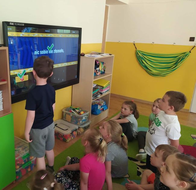 Przedszkolak wykonuje zadanie na tablicy interaktywnej