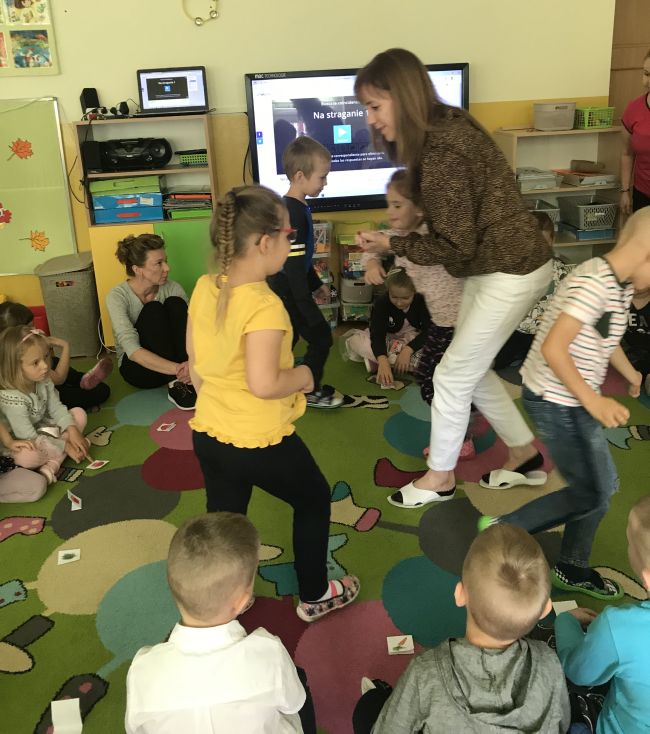 Przedszkolaki biegają po sali, bawią sie w grę 