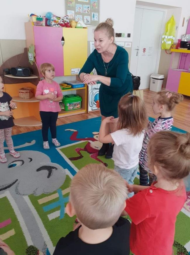 Nauczyciel prowadzi zabawę ruchową, dzieci naśladują jego gesty.