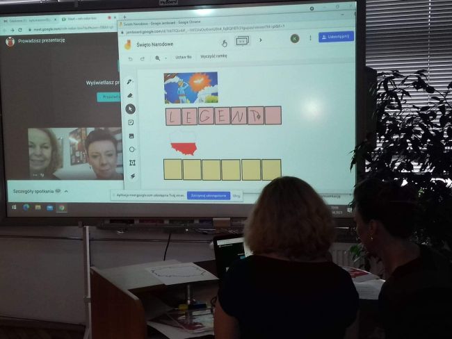 Nauczyciele bibliotekarze prowadzący zajęcia pracują przy laptopie. Na tablicy interaktywnej wyświetlone zadanie dla przedszkolaków