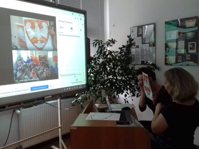 Nauczyciele bibliotekarze prowadzący zajęcia pracują przy laptopie. 