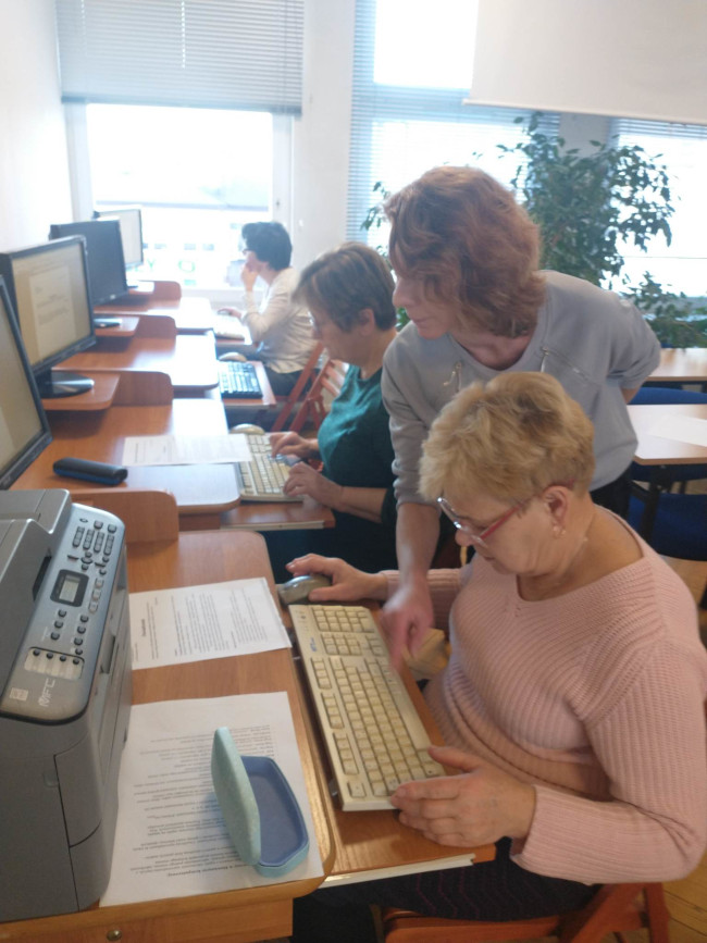 Uczestnicy pracują przy komputerach, wykonując polecenia prowadzącej