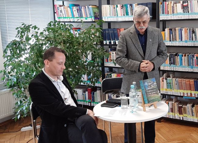 Przy stoliku autor i prowadzący spotkanie
