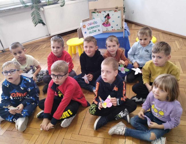 Zdjęcie grupowe przedszkolaków siedzących na podłodze.