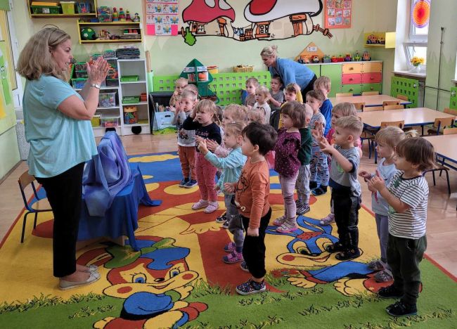Zabawa ruchowa. Dzieci stoją i  naśladują prowadzącą zajęcia
