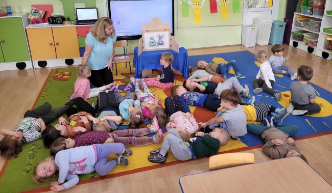 Zabawa ruchowa. Dzieci leżą na podłodze, wykonują ćwiczenia relaksacyjne.