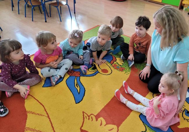 Zabawa ruchowa. Dzieci stoją i  naśladują prowadzącą zajęcia