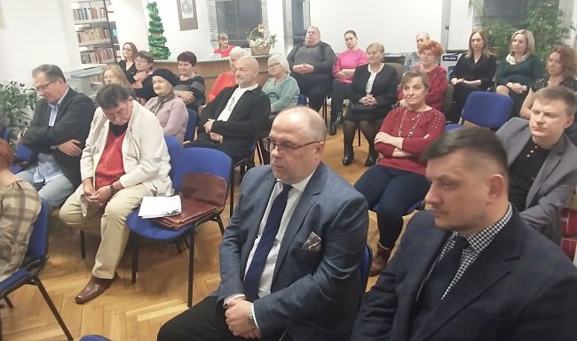 Żdjęcie gości przybyłych na spotkanie. W tle zaproszeni poeci.