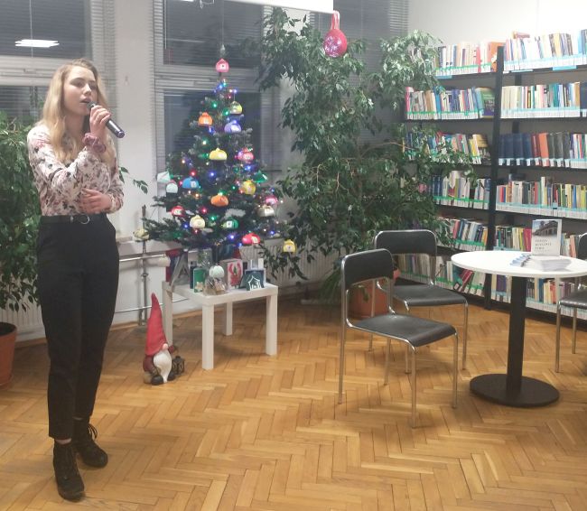 Część artystyczna. Uczennica śpiewa do mikrofonu.