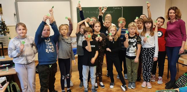 Wspólna fotografia, na której uczniowie prezentują wykonane metodą origami gwiazdki.