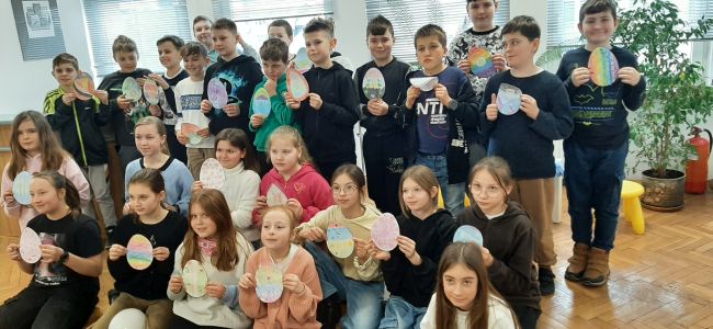 Zdjęcie zbiorowe. Uczniowie trzymają w rękach własnoręcznie wykonane pisanki z papieru.