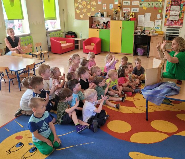 Dzieci siedzą na podłodze, słuchają opowieści1