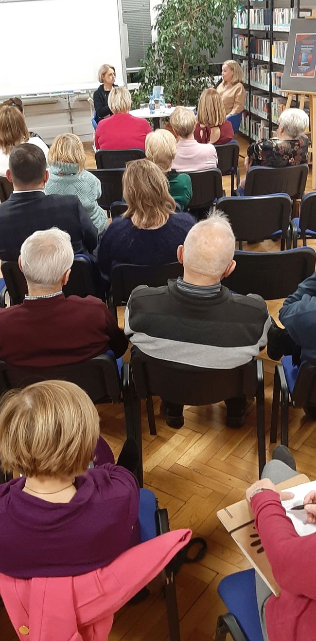 Prowadząca, przy stoliku, prowadzi rozmowę z  autorką Moniką Tadrą 