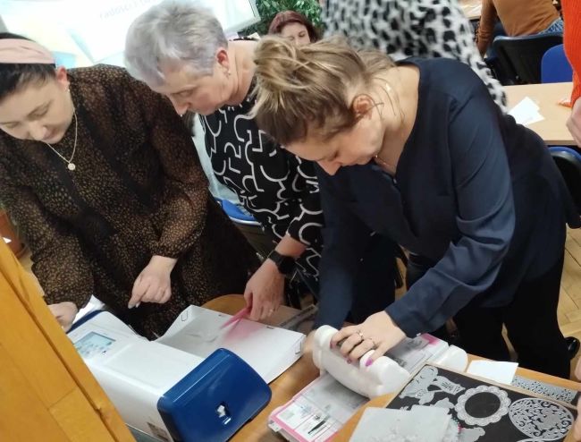 Uczestnicy warsztatów wycinają elementy z papieru do kartek wielkanocnych