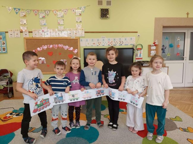 Wspólne zdjęcie przedszkolaków z bajkową kolejką.