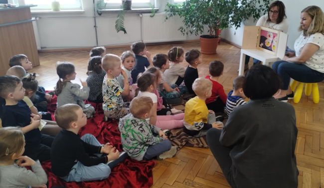 Dzieci słuchają opowiadania, teatrzyku Kamishibai pt. „Mój przyjaciel Kemyshi”