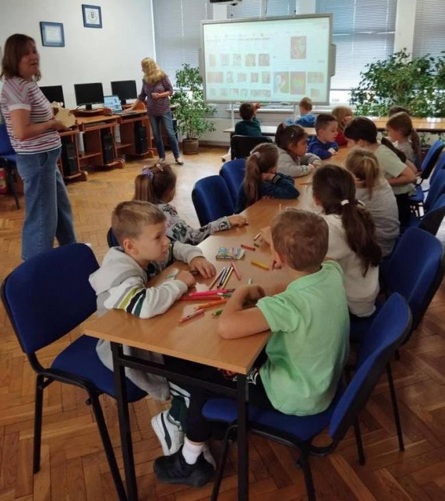 Uczniowie siedzą przy stolikach, wykonują rysunek