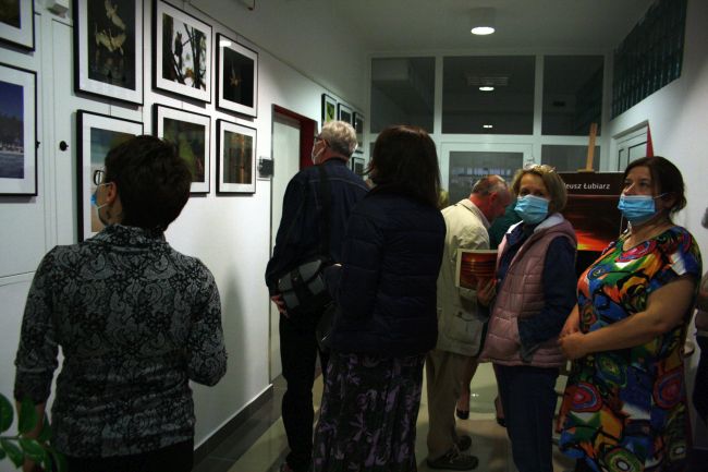 fotografia przedstawia prace pokazane na wystawie i osoby uczestniczące w otwarciu wystawy