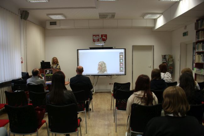 Zdjęcie przedstawia zapełnioną ludźmi czytelnię biblioteki pedagogicznej podczas konferencji Podróże z Lemem. Na zdjęciu widoczna Anetta Sienkiewicz, wicedyrektor biblioteki pedagogicznej, która otwiera konferencję
