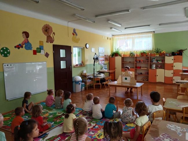 prowadząca zajęcia i grupa słuchających dzieci