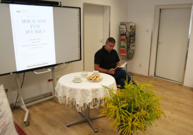 Pan Dariusz Kapitan - nauczyciel bibliotekarz Biblioteki Pedagogicznej w Zamościu czyta fragment „Moralności pani Dulskiej” Gabrieli Zapolskiej.