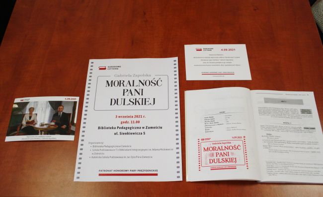 Druki okolicznościowe, plakat ogólnopolskiej akcji Narodowego Czytania i otwarta na pierwszej stronie książka „Moralności pani Dulskiej” Gabrieli Zapolskiej.