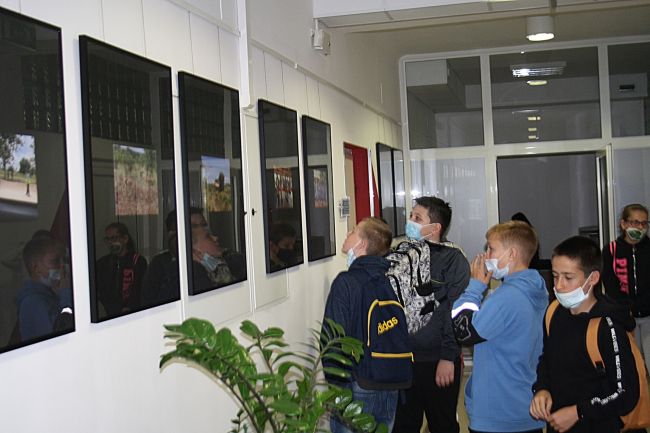 Uczestnicy spotkania autorskiego oglądający wystawę