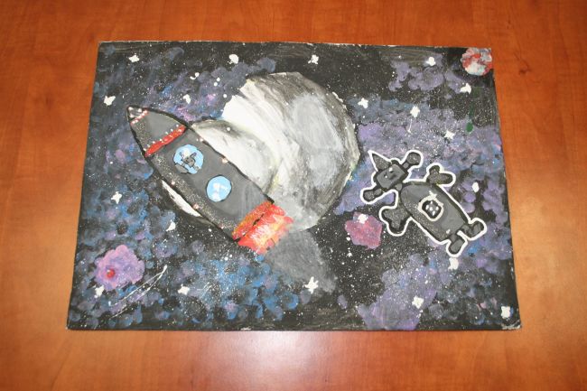 praca plastyczna przedstawiająca lecąca rakieta w kosmosie