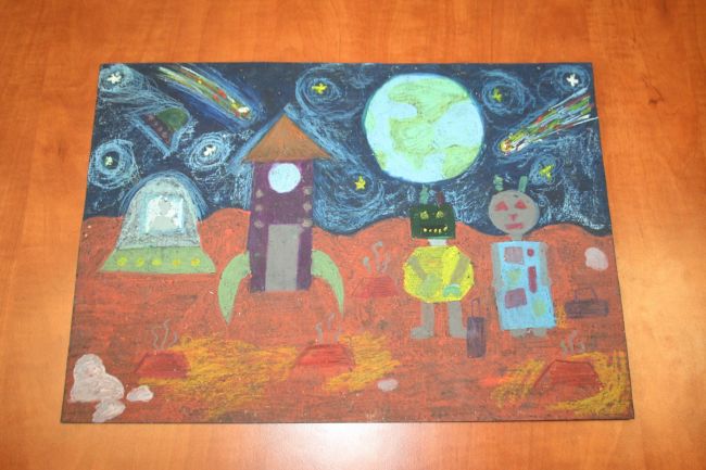 praca plastyczna przedstawiająca kosmos, rakietę i 2 stworki kosmiczne