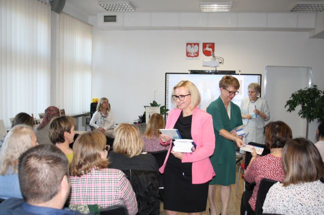 Na zdjęciu Aneta Bartoszczyk-Trochimiuk oraz Dorota Mach rozdają publiczności egzemplarze książek 