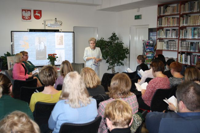 Zdjęcie z końca sali, widać od tyłu widownię, a z przodu Marię Duławską.