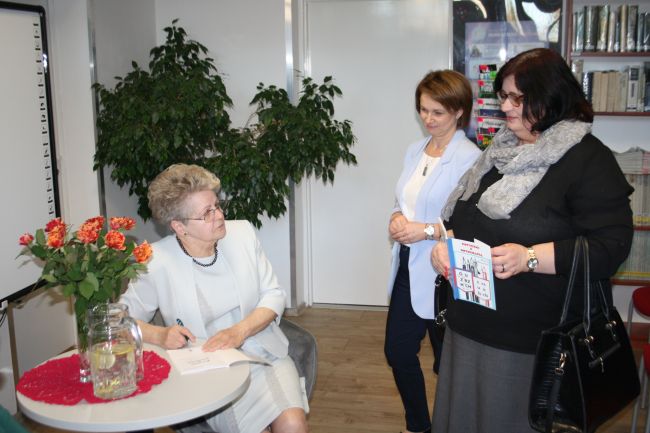 Na zdjęciu widać Marię Duławską podpisującą swoją książkę, a także dwie nauczycielki oczekujące na autografy.