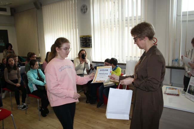 Laureatka konkursu odbiera dyplom i nagrodę od dyrektora Biblioteki Pedagogicznej w Zamościu.