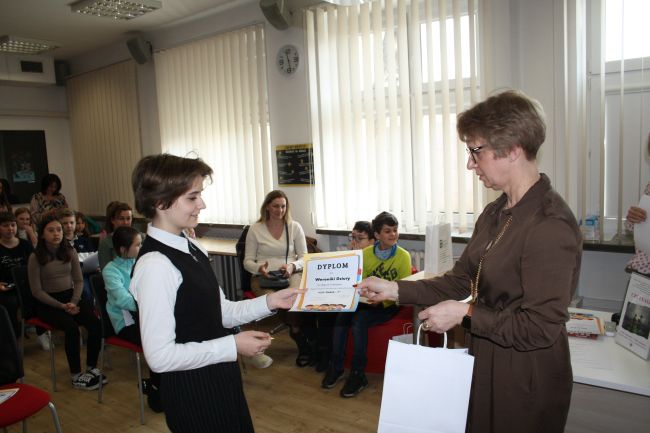 Laureatka konkursu odbiera dyplom i nagrodę od dyrektora Biblioteki Pedagogicznej w Zamościu.