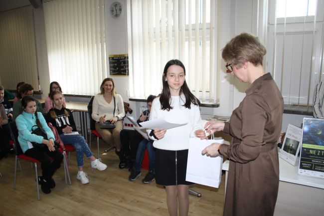 Barbara Podoba, która zajęła 1 miejsce w konkursie, odbiera dyplom i nagrodę od dyrektora Biblioteki Pedagogicznej w Zamościu.
