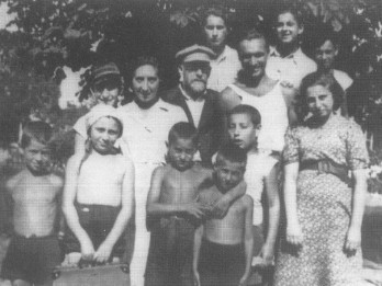 Na czarno-białym zdjęciu Janusz Korczak i wychowawca Misza Wróblewski z wychowankami przed budynkiem Domu Sierot (1934 lub 1935)
