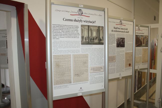 Zdjęcie wystawy historycznej poświęconej Komisji Edukacji Narodowej. Na wystawie znajdują się plakaty z informacjami o działalności Komisji Edukacji Narodowej wraz z ilustracjami.