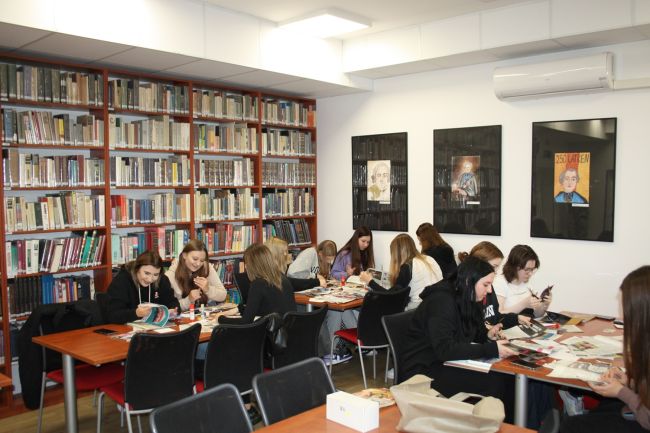 Uczestnicy warsztatów poświęconych Wisławie Szymborskiej pracują nad kartkami w stylu noblistki.

