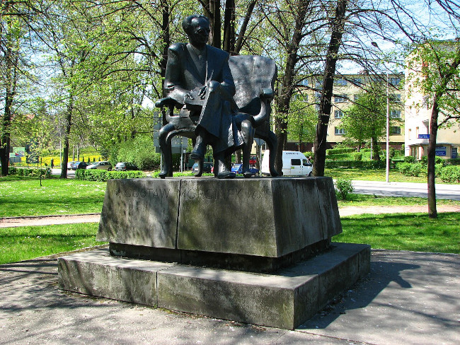 Pomnik Gustawa Morcinka w Skoczowie, projektu prof. Jana Kucza, odsłonięty 1987. Pomnik ma postać ławki, na której siedzi Gustaw Morcinek, ubrany w garnitur, w rękach trzyma książkę.