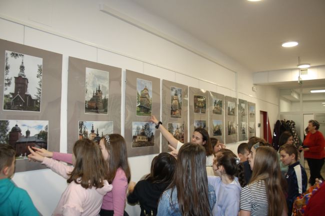 Na zdjęciu widać, jak uczestnicy wernisażu oglądają wyeksponowane fotografia Artura Wąsika.