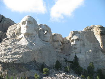 Zdjęcie przedstawia podobizny zasłużonych prezydentów Stanów Zjednoczonych wyrzeźbionych w masywie górskim Mount Rushmore w Dakocie Południowej. Rzeźba pierwsza od prawej przedstawia prezydenta Abrahama Lincolna.