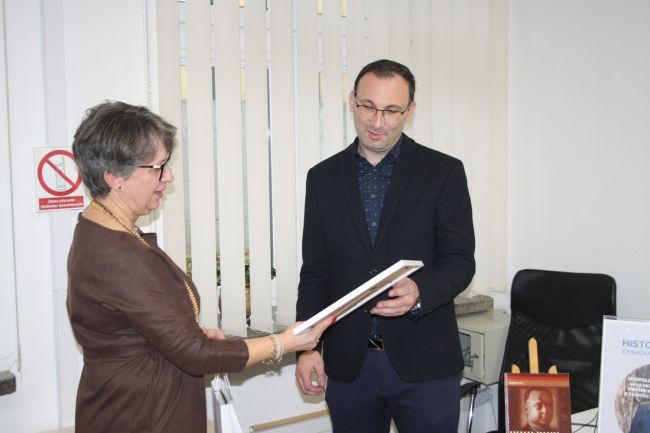 Dyrektor Biblioteki Pedagogicznej wręcza prelegentowi pamiątkowy upominek w podziękowaniu za spotkanie autorskie.