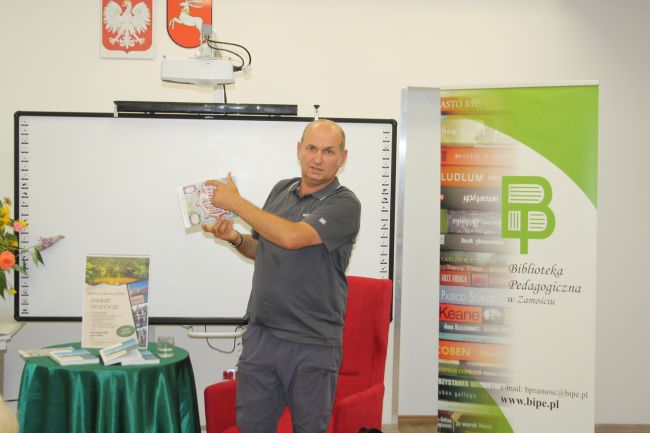 Janusz Malicki trzyma kartkę z grafiką planu Zamościa.